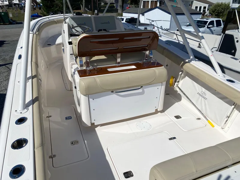 Slide: The Image of 2016 Pursuit S 280 Sport boat interior with beige seating and wooden accents. - 20
