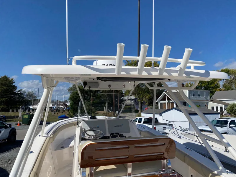 Slide: The Image of 2016 Pursuit S 280 Sport boat with rod holders and helm, docked under clear blue sky. - 21