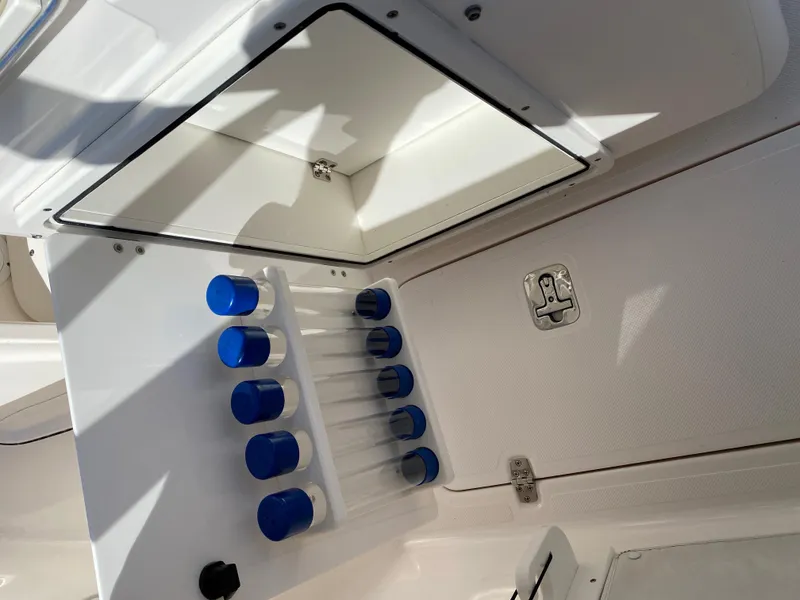 Slide: The Image of 2016 Pursuit S 280 Sport boat storage compartment with blue rod holders. - 22