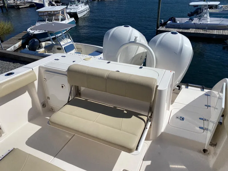 Slide: The Image of 2016 Pursuit S 280 Sport boat with dual engines and beige seating at a marina. - 24