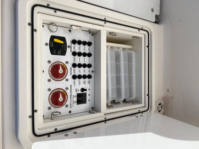 Slide: The Image of Control panel of a 2016 Pursuit S 280 Sport boat, featuring switches and storage compartments. - 26