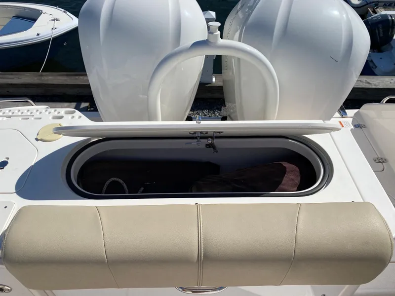 Slide: The Image of 2016 Pursuit S 280 Sport boat with open storage compartment and cushioned seating. - 27
