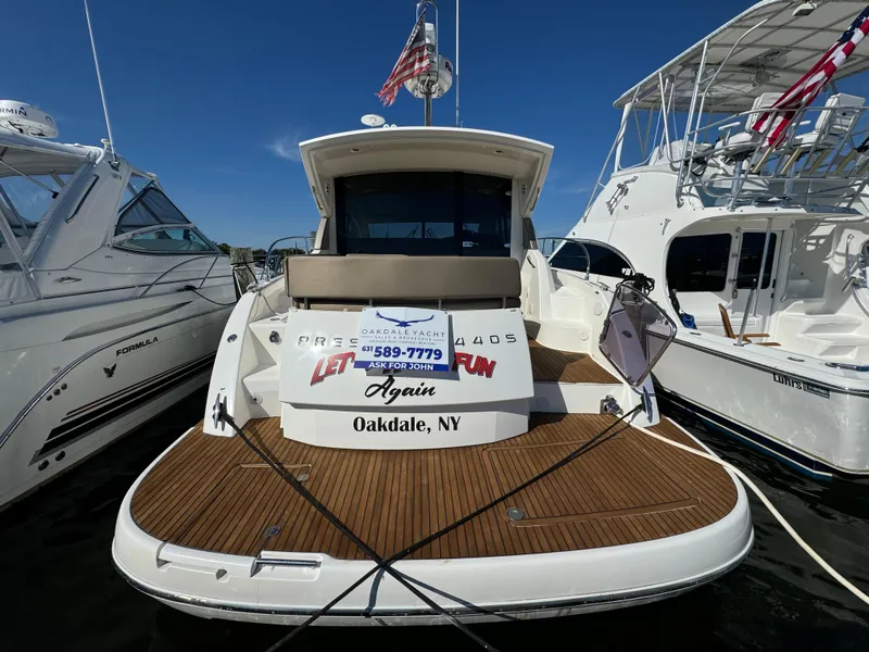 Slide: The Image of 2012 Prestige 440 S yacht docked in Oakdale, NY, with wooden deck and American flag. - 17