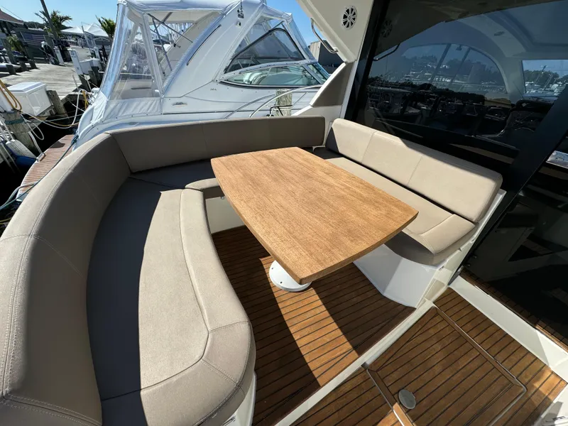 Slide: The Image of Luxurious 2012 Prestige 440 S yacht with elegant seating and wooden table on deck. - 18