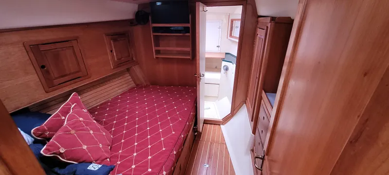 Slide: The Image of Cozy cabin interior of 1997 Saga 43 yacht with red bedding and wooden furnishings. - 12