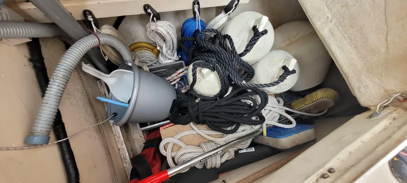 Slide: The Image of Storage compartment with ropes, fenders, and cleaning tools on a 1997 Saga 43 boat. - 24