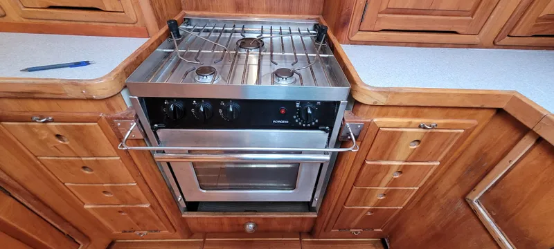 Slide: The Image of Wooden kitchen with a stainless steel stove and oven in a 1997 Saga 43 boat. - 31