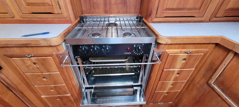 Slide: The Image of Wooden kitchen with a stainless steel stove and oven on a 1997 Saga 43 boat. - 32