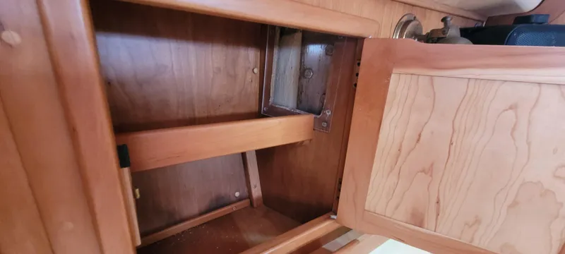 Slide: The Image of Wooden cabinet interior of a 1997 Saga 43 boat, open door, empty shelves. - 39