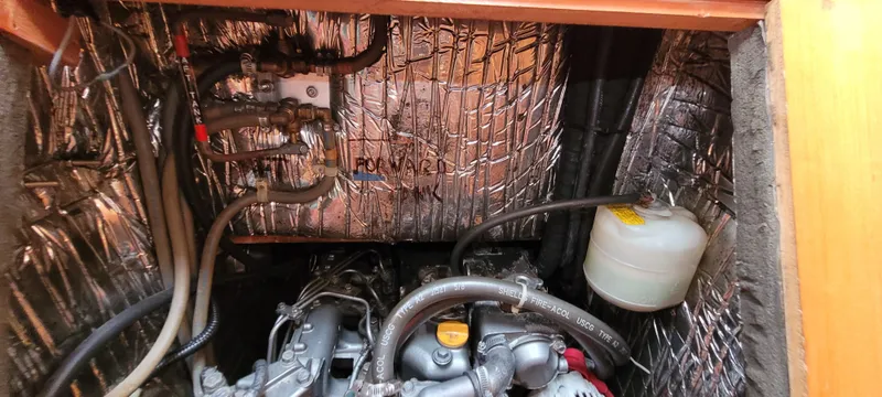 Slide: The Image of Engine compartment of a 1997 Saga 43 boat with insulation and visible hoses. - 49