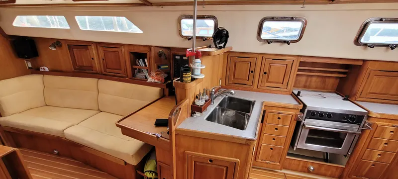 Slide: The Image of Interior of 1997 Saga 43 sailboat with wooden cabinetry and cozy seating area. - 6