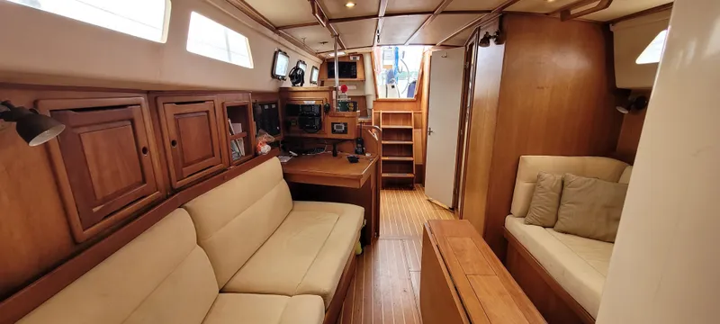 Slide: The Image of Interior of 1997 Saga 43 sailboat with wooden furnishings and beige seating. - 9