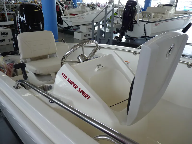Slide: The Image of 2024 Boston Whaler 130 Super Sport boat displayed in showroom on trailer. - 6