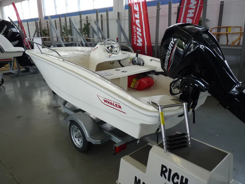 Slide: The Image of 2024 Boston Whaler 130 Super Sport boat interior with steering wheel and seating. - 7