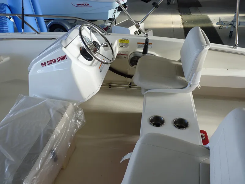 Slide: The Image of 2024 Boston Whaler 160 Super Sport interior with steering wheel and seating. - 10