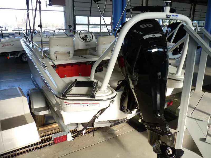 Slide: The Image of 2024 Boston Whaler 160 Super Sport boat with powerful outboard motor in showroom. - 3