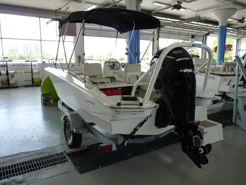 Slide: The Image of 2024 Boston Whaler 160 Super Sport boat in showroom, rear view with motor. - 4