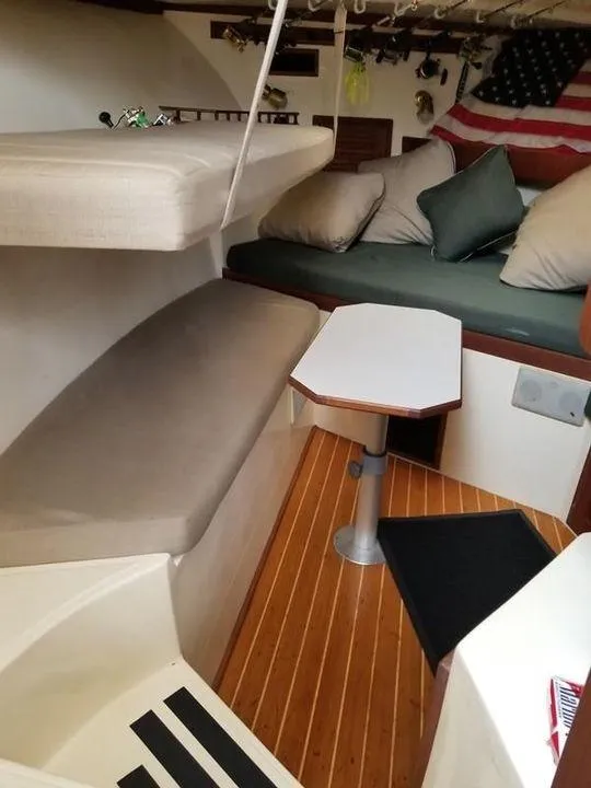 Slide: The Image of Interior of 1996 Albemarle 305 boat with seating, table, and American flag decor. - 13