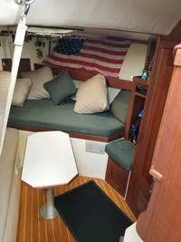 Slide: The Image of 1996 Albemarle 305 boat interior with American flag and cozy seating area. - 14