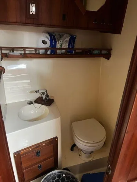 Slide: The Image of 1996 Albemarle 305 boat bathroom with sink, toilet, and storage shelves. - 16