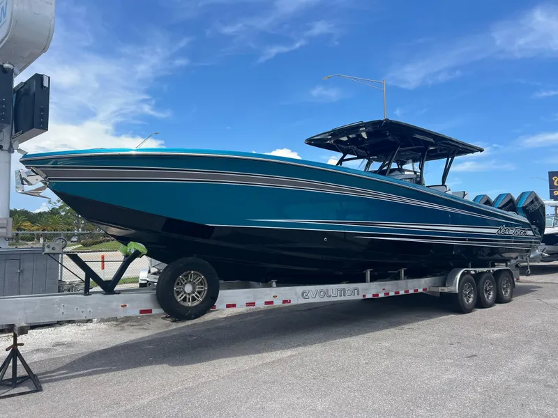 Slide: The Image of 2025 Nor-Tech 390 Sport Center Console boat on trailer, blue and black design. - 0