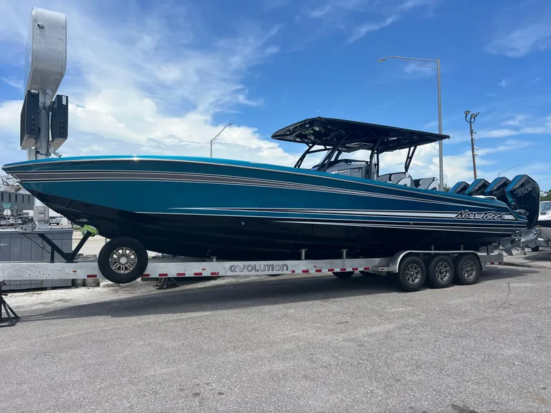 Slide: The Image of 2025 Nor-Tech 390 Sport Center Console boat on trailer, vibrant blue design. - 1