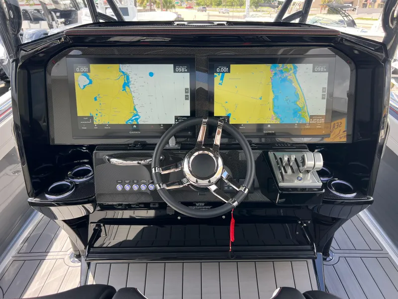 Slide: The Image of 2025 Nor-Tech 390 Sport Center Console dashboard with dual navigation screens and steering wheel. - 10