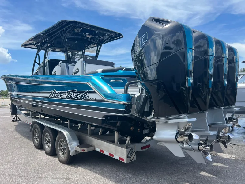 Slide: The Image of 2025 Nor-Tech 390 Sport Center Console boat on trailer, featuring triple outboard engines. - 2