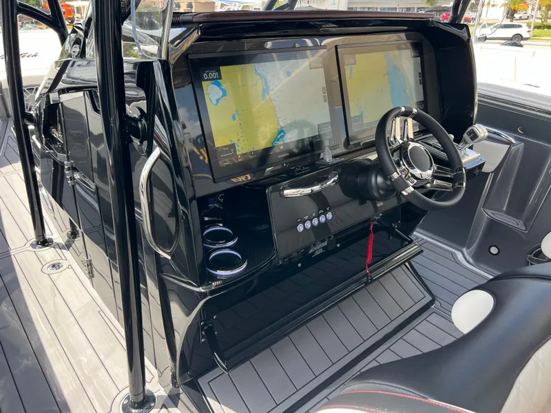 Slide: The Image of 2025 Nor-Tech 390 Sport Center Console with dual navigation screens and sleek black interior. - 9