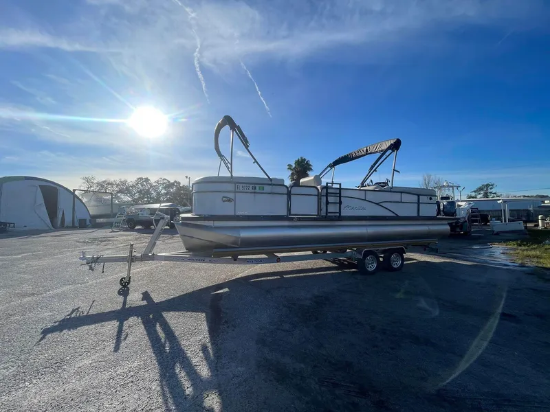 Slide: The Image of 2017 Manitou 25 Oasis pontoon boat on trailer under bright sun. - 8