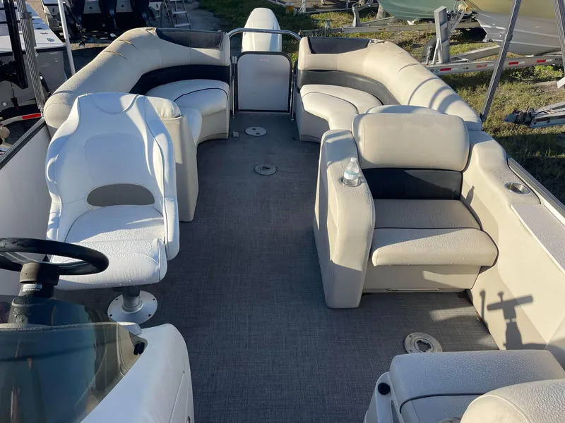 Slide: The Image of 2017 Manitou 25 Oasis pontoon boat interior with spacious seating and steering wheel. - 9