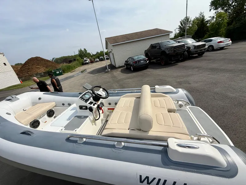 Slide: The Image of 2019 Williams Jet Tenders Sportjet 395 in a parking lot, showcasing beige seating and controls. - 23