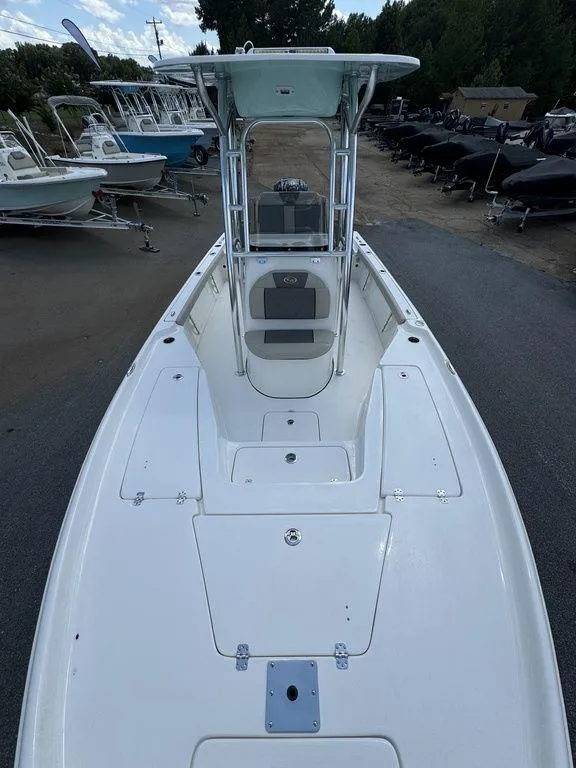 Slide: The Image of 2025 Key West 230 BR boat, sleek white design, spacious deck, parked outdoors. - 10