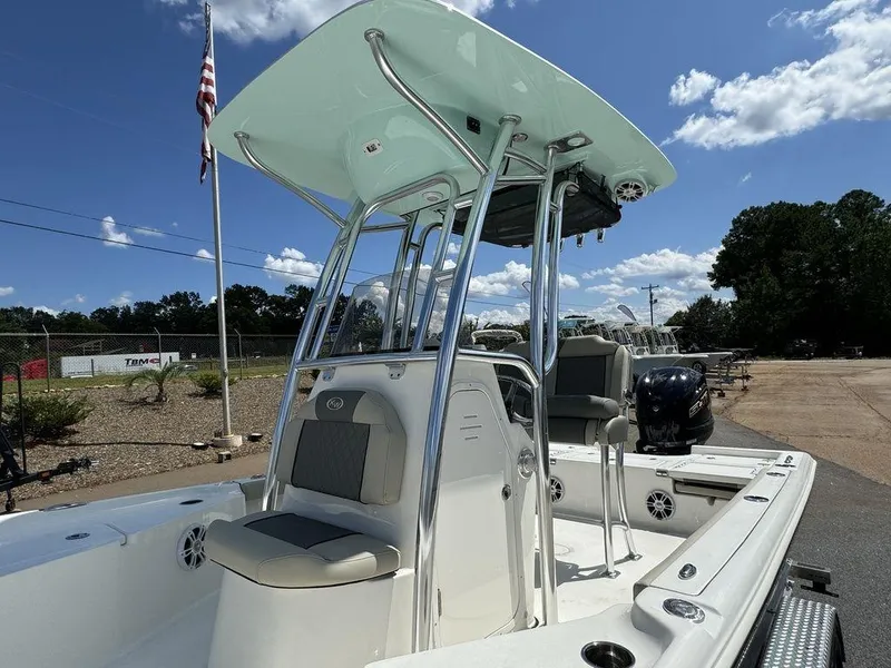 Slide: The Image of 2025 Key West 230 BR boat with T-top, parked outdoors under blue sky. - 11