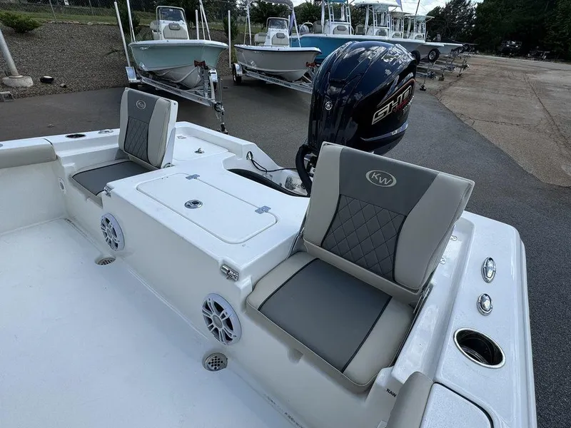 Slide: The Image of 2025 Key West 230 BR boat interior with seating and motor, docked outdoors. - 14