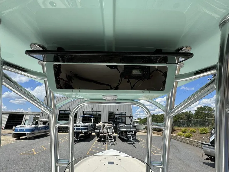 Slide: The Image of 2025 Key West 230 BR boat with T-top, docked among other boats. - 5