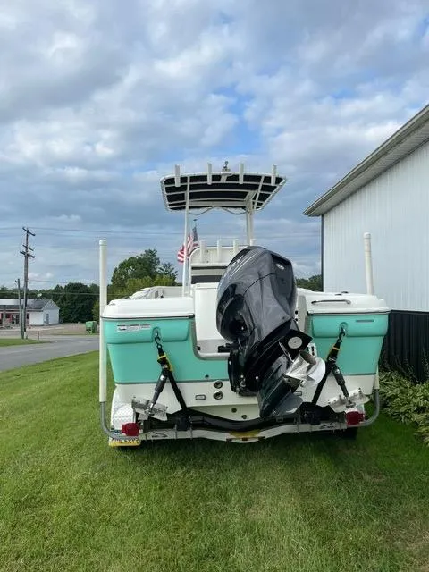Slide: The Image of 2016 Clearwater 2200 WI Center Console boat with outboard motor, parked on grass. - 2