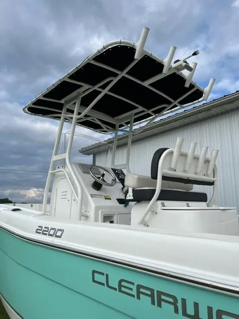 Slide: The Image of 2016 Clearwater 2200 WI Center Console boat with T-top and rod holders, under cloudy sky. - 3