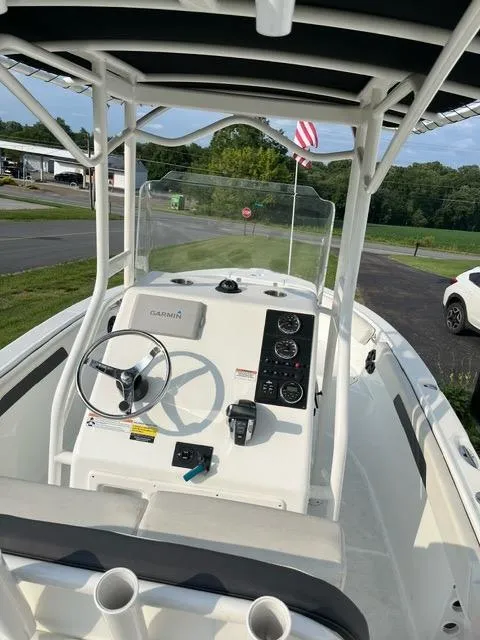 Slide: The Image of 2016 Clearwater 2200 WI Center Console boat with steering wheel and control panel, parked outdoors. - 4
