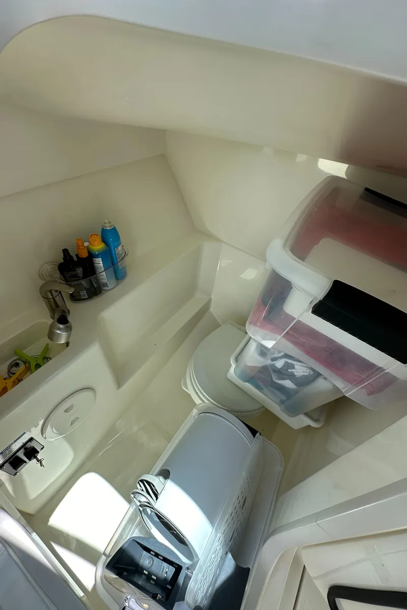 Slide: The Image of 2021 Boston Whaler 240 Vantage interior storage area with various items and containers. - 15