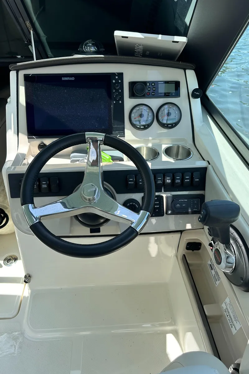 Slide: The Image of 2021 Boston Whaler 240 Vantage helm with steering wheel and navigation controls. - 19