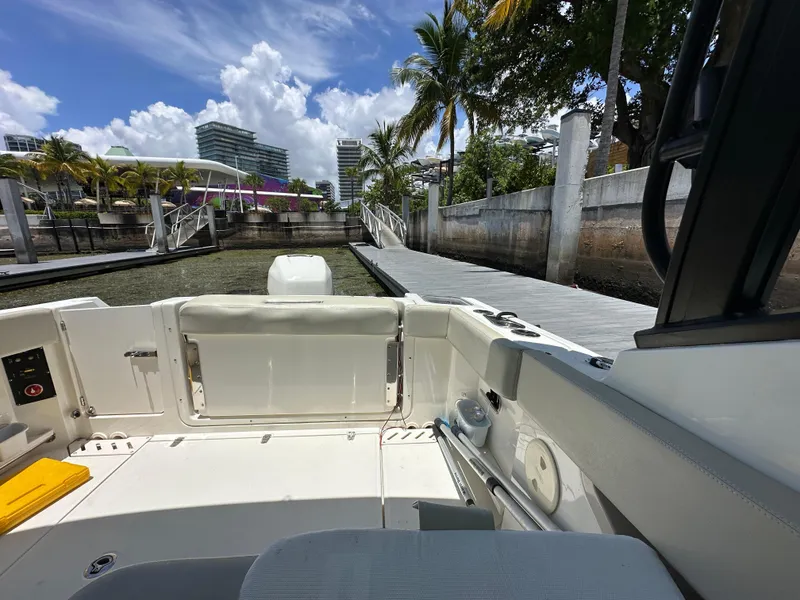 Slide: The Image of 2021 Boston Whaler 240 Vantage boat docked near a marina with palm trees. - 5