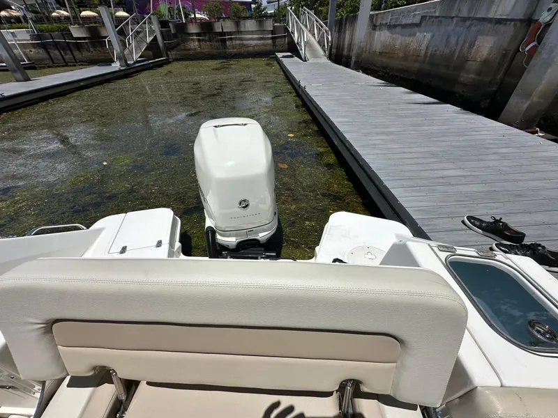 Slide: The Image of 2021 Boston Whaler 240 Vantage boat docked, rear view with outboard motor. - 7