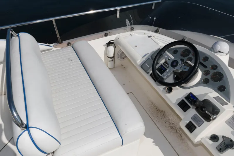 Slide: The Image of 2007 Fairline Phantom 46 yacht helm with white seating and control panel. - 12