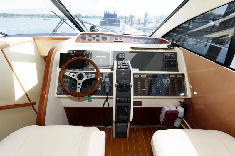 Slide: The Image of 2007 Fairline Phantom 46 yacht helm with wooden steering wheel and modern navigation controls. - 20