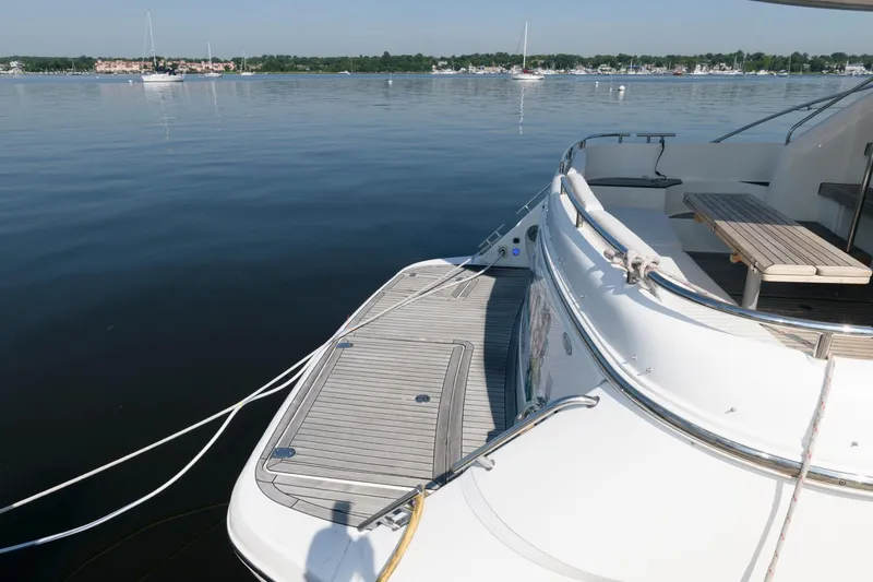 Slide: The Image of 2007 Fairline Phantom 46 yacht docked on calm water, featuring spacious deck and seating area. - 6
