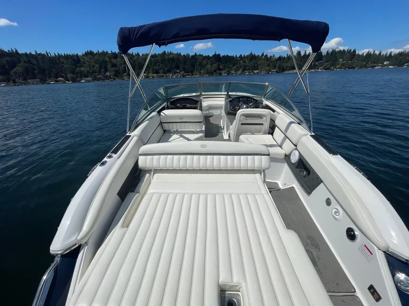 Slide: The Image of 2011 Cobalt A25 boat with white seating, on a serene lake under a blue sky. - 10