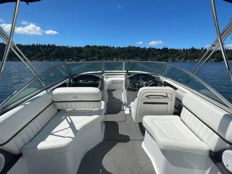 Slide: The Image of 2011 Cobalt A25 boat interior with white seating, on a lake under blue skies. - 11