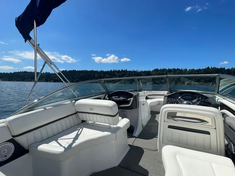 Slide: The Image of 2011 Cobalt A25 boat interior with white seating, on a sunny lake. - 12