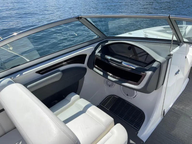 Slide: The Image of Interior of a 2011 Cobalt A25 boat with white seating and dashboard. - 13